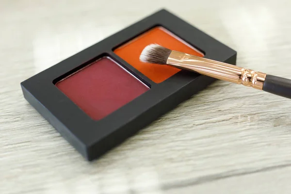 Paleta con sombras y pinceles sobre la mesa en el salón de belleza — Foto de Stock