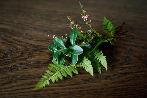 Beautiful autumn bouquet of the last green plants on a wooden su — Stock Photo, Image