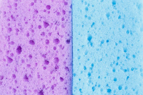 Spugne colorate per il lavaggio dei piatti e altre esigenze domestiche. Vista dall'alto. Texture di due spugne viola e blu, gommapiuma — Foto Stock