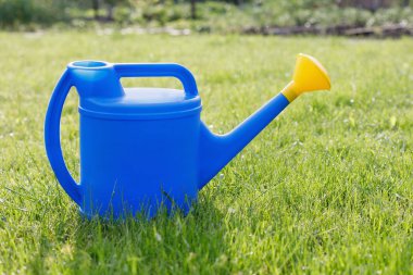 mavi plastik sulama yeşil bir çim üzerinde sarı bir lens ile olabilir