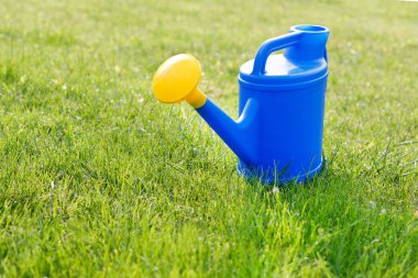 mavi plastik sulama yeşil bir çim üzerinde sarı bir lens ile olabilir