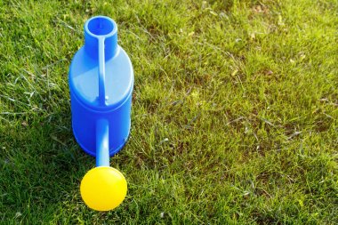 mavi plastik sulama yeşil bir çim üzerinde sarı bir lens ile olabilir