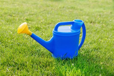 mavi plastik sulama yeşil bir çim üzerinde sarı bir lens ile olabilir