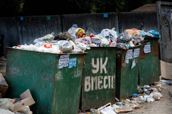 Voronezh, Russia - June 18, 2019. Garbage cans overflowing with debris and waste. Untimely removal. Large inscription in Russian: UK TOGETHER . — Stock Photo, Image