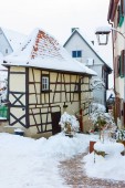 Történelmi, középkori favázas házak Bad Wimpfen-ben, Németországban. Cserepes háztetők és a régi macskaköves út borított hó.