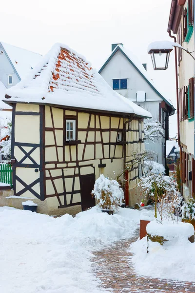 Historic, medieval half-timbered houses in Bad Wimpfen, Germany. Tiled roofs of houses and old cobbled road covered with snow. — Stock Photo, Image
