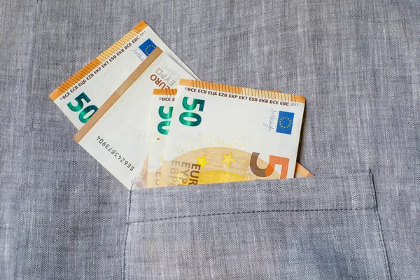Varios billetes de 50 euros están en un bolsillo de lona. El concepto de ganar, ahorrar o gastar dinero . — Foto de Stock