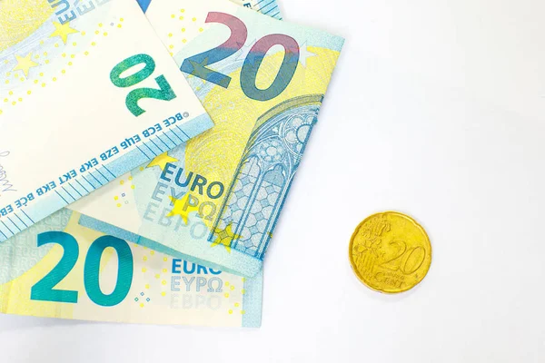 Varios billetes de 20 euros y una moneda de 20 centavos. El concepto de oponerse a las ganancias grandes y pequeñas, ahorrar o gastar dinero . — Foto de Stock