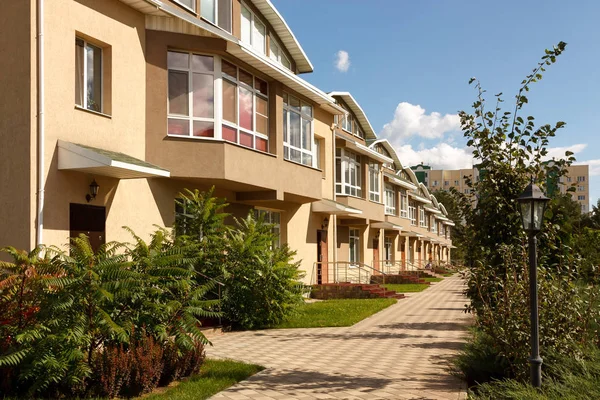 Una fila de casas nuevas en un pueblo suburbano en un día soleado . —  Fotos de Stock