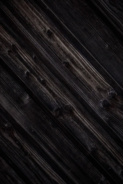 Fondo de madera marrón oscuro. Las tablas de madera natural están saturadas con aceite oscuro. Tableros verticales con nudos, clavos y un perno se encuentran en un ángulo . — Foto de Stock