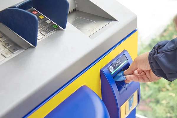 Eine weibliche Hand steckt eine Plastikkarte in einen Geldautomatenschlitz. das Konzept der sicheren Verwendung von Bankkarten, Überweisungen, Zahlungen für Dienstleistungen und Waren, Empfang von Bargeld. Nahaufnahme — Stockfoto