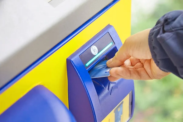 Nimmt eine weibliche Hand eine Plastikkarte aus einem Geldautomatenschlitz. das Konzept — Stockfoto