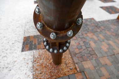 Fayans bulanıklığı arka planı üzerindeki demir boruların cıvatalı bağlantıları. Yukarıdan Perspektif. Endüstriyel konsept.