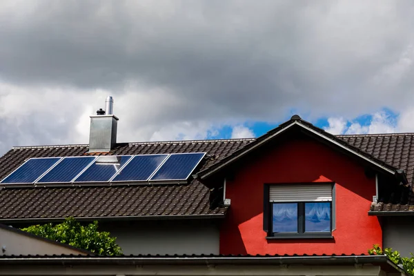 Solar panels on the roof of a house in cloudy weather. The concept of poor location, bad weather, and payback. — Stock Photo, Image