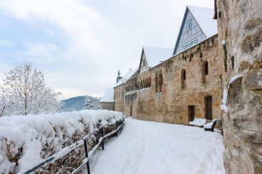 Almanya 'nın Bad Wimpfen kentinin etrafındaki kale duvarı. Evin fayanslı çatısı, ağaçlar ve çalılar yoğun bir şekilde karla kaplı. Kış fotoğrafı