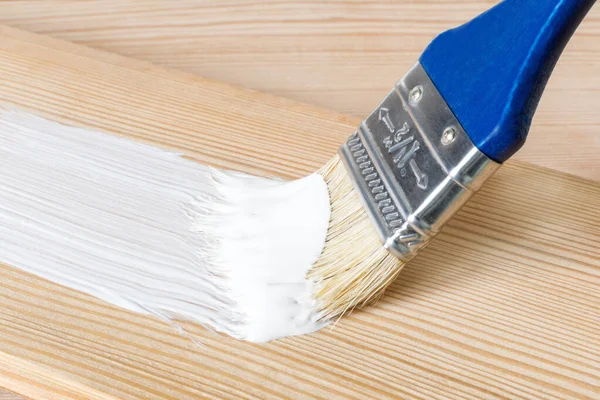 Ein Schmierfilm weißer Farbe auf einem Holzbrett für ein klassisches skandinavisches Design. minimalistische Inneneinrichtung mit Holz und weißen Details. Selektiver Fokus — Stockfoto