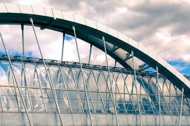 Yaya geçidinin yükseltilmiş bir parçası var. Gökyüzüne karşı yükselen elementlerle askıya alınmış bir yaya köprüsünün kemer destek kirişi