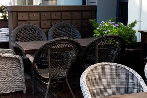 Wicker Chairs A Wooden Table And A Chest Of Drawers For An Outdoor Cafe Empty Wooden