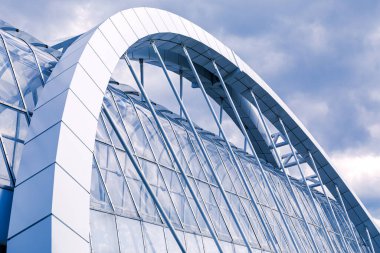 Yaya geçidinin yükseltilmiş bir parçası var. Asılı bir yaya köprüsünün kemer destek kirişi ve gökyüzüne karşı yükselen elementler. Tek renkli resim