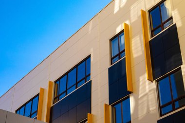 Pencereli bej ve kahverengi modern havalandırmalı cephe. Yeni elit bir konut binasının ya da alışveriş merkezinin parçası. Şehir gayrimenkullerinin bir parçası