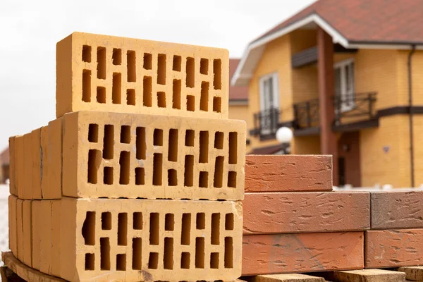 A stack of yellow and brown hollow bricks on a construction site. — Stock Photo, Image