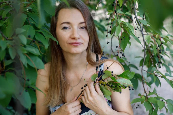 Güzel, olgun, uzun saçlı bir kadın ağaçtan kiraz meyvesi toplar. Köydeki Avrupalı bir kadının günlük hayatı. Yaşam biçimi