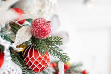 Yapay ağaç beyaz ve kırmızı toplar ve süslemelerle süslenmiştir..