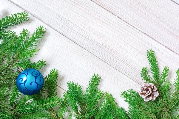 Noel ya da yeni yıl dekorasyonları arka planı: ağaç dalları ve çam kozalağı şeklinde mavi Noel oyuncağı. Boşluğu kopyala — Stok fotoğraf