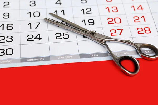 stock image Calendar with hairdressing scissors. Haircut appointment concept. Close-up