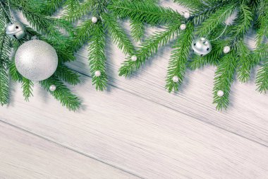 Noel ya da yeni yıl arkaplanı: köknar dalları ve beyaz tahta üzerinde Noel oyuncakları düz yatıyordu. Boşluğu kopyala.