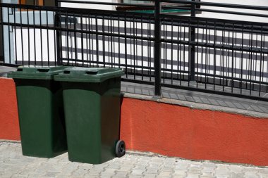 Evin önündeki yeşil çöp bidonları. Yol kenarındaki umumi çöpler..