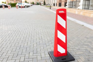 Dairenin yakınındaki yolda kırmızı beyaz bir park yeri var. Boşluğu kopyala