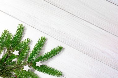 Noel arkaplanı. Beyaz tahta üzerinde köknar dallarından yapılmış Noel çerçevesi. Düz yatıyordu. Boşluğu kopyala.