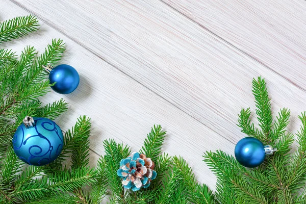 Noel arkaplanı. Köknar dallarından ve beyaz tahta üzerinde mavi Noel oyuncaklarından oluşan yeni yıl çerçevesi. Düz konum, boşluğu kopyala. — Stok fotoğraf
