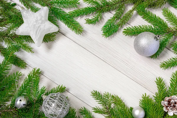 Noel arkaplanı. Noel çerçevesi beyaz tahta üzerinde köknar dalları ve Noel oyuncaklarından yapılmış. Düz konum, boşluğu kopyala. — Stok fotoğraf