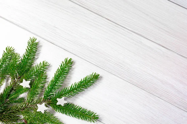 Χριστουγεννιάτικο φόντο. Χριστουγεννιάτικο καρέ από κλαδιά ελάτης σε λευκό ξύλο. Επίπεδη. Αντιγραφή χώρου. — Φωτογραφία Αρχείου