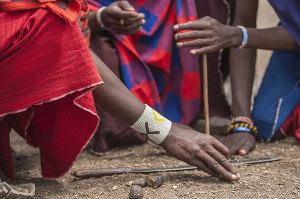 Traditional tribal bead work worn around wrist by Masai man as he lights a fire using traditional method of stone and stick. Tanangire National Park, Tanzania