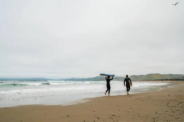 Amis avec des planches de surf sur la plage — Photo