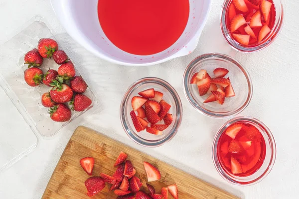 Strawberry Jelly Preparation. Sliced Strawberries in Clear Glass Bowls, Sliced Strawberries on a Chopping Board. Dessert