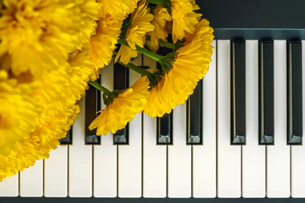 Flowers on a Piano. Bouquet of Yellow Chrysanthemum on a Piano Keyboard Close Up Top View