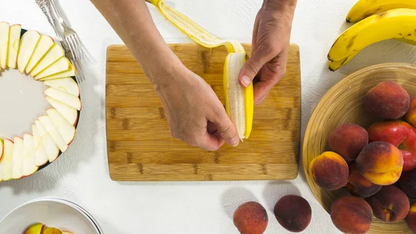 Banana Slices on a Wooden Chopping Board. Woman Peeling and  Slicing Bananas. Arranging Fruit Platter