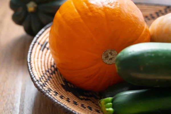 Squash family. Fresh, organic acorn squash, butternut squash, and pumpkin close up on a wooden background