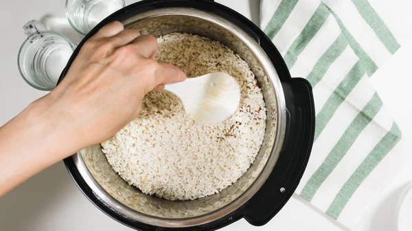 Rice in a pot. Cooking rice with meat and vegetables  in pressure multi cooker step by step, top view.