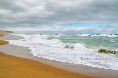 Güzel deniz manzarası. Fırtınalı okyanus ve bulutlu gökyüzü. Sakin sahne, boş plaj, tatil, rahatlama konsepti..
