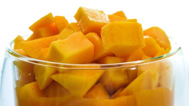Bir kase taze doğranmış mango meyvesi beyaz arka planda kapanıyor.