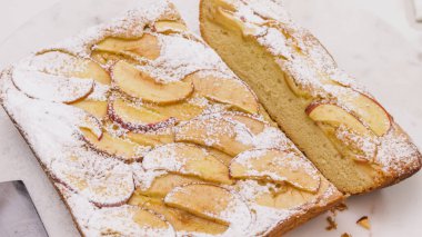 Elmalı pasta. Taze pişmiş elmalı bisküvi. Beyaz arka planda yakın plan. Kadın pasta keser.