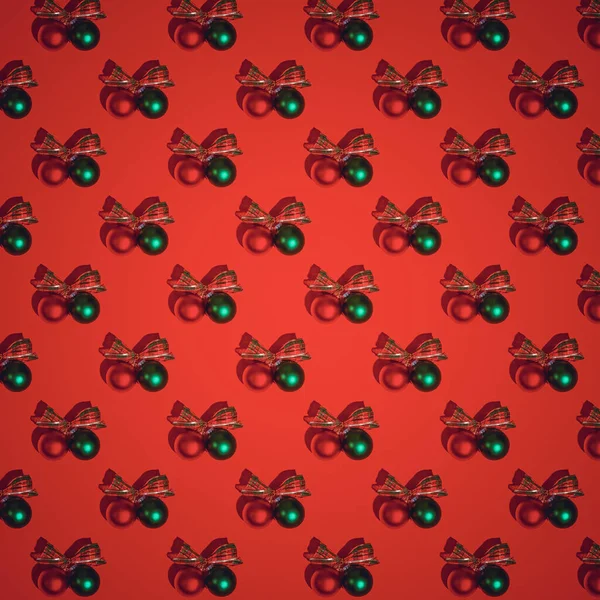 Red Christmas pattern. Red and green satin glass Christmas bulbs on red background