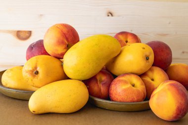 Sarı mango ve şeftali. Taze taze organik tropikal meyveler kapanıyor.