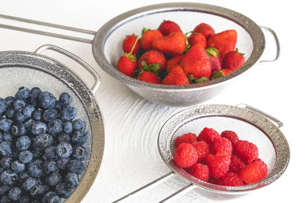 Verse Rijpe Gewassen Aardbeien Bosbessen Frambozen Colanders Close Witte Achtergrond — Stockfoto