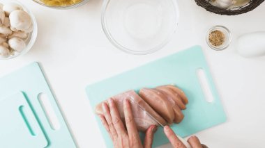 Şef taze çiğ tavuk filetosu dilimliyor, manzarayı kapat, düz yat, kopyala alanı